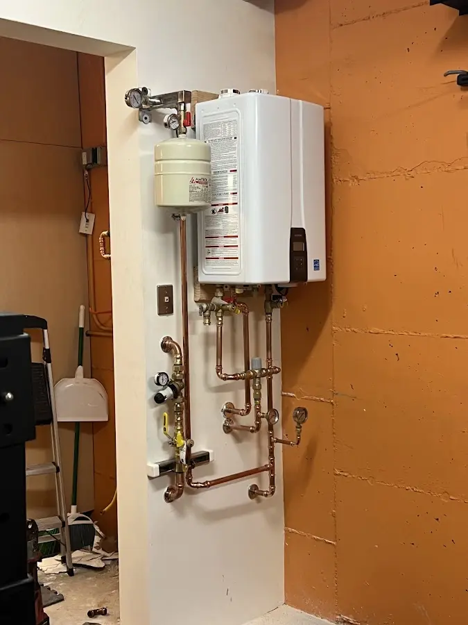 Plumbing technician inspecting water heater connections in Nashua